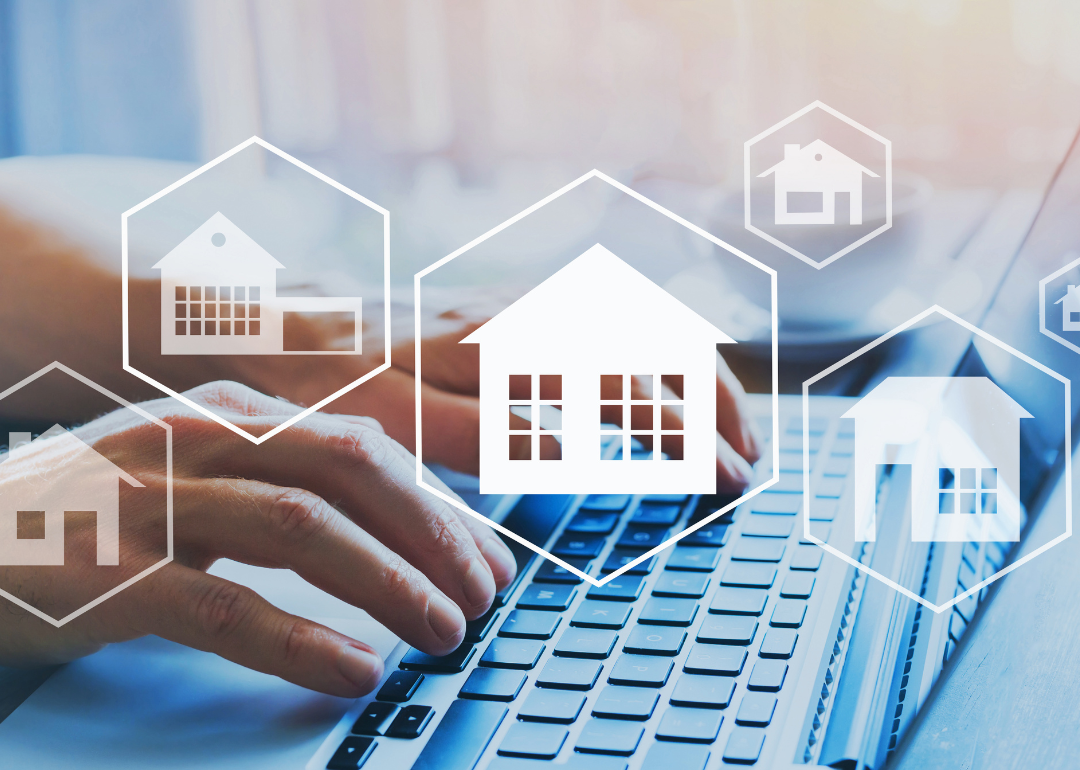 Hands working over a keyboard with superimposed images of real estate holdings matted over the photo, symbolizing investments taking place online