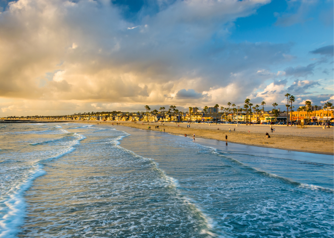Waves in the Pacific Ocean and view of the beach at sunset, in Newport Beach, California