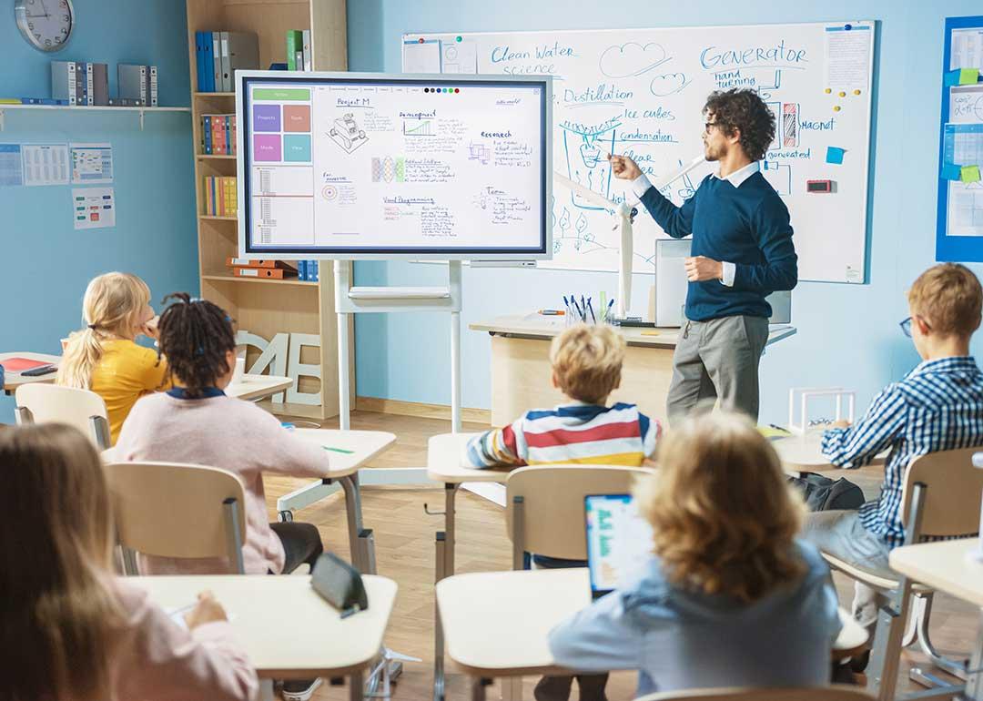 classroom setting POV students watching teacher at whiteboard 