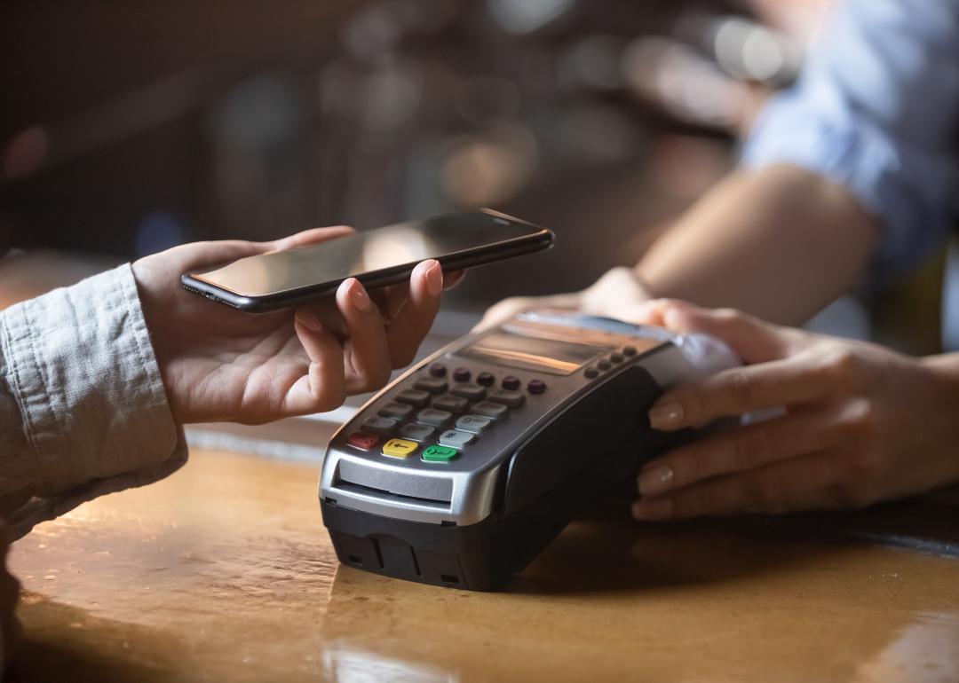 woman spending money and paying via smartphone