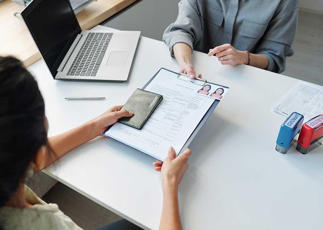 person submitting legal documents across desk