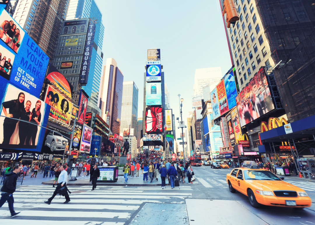 Times Square in New York City, with lit-up billboards and people walking by