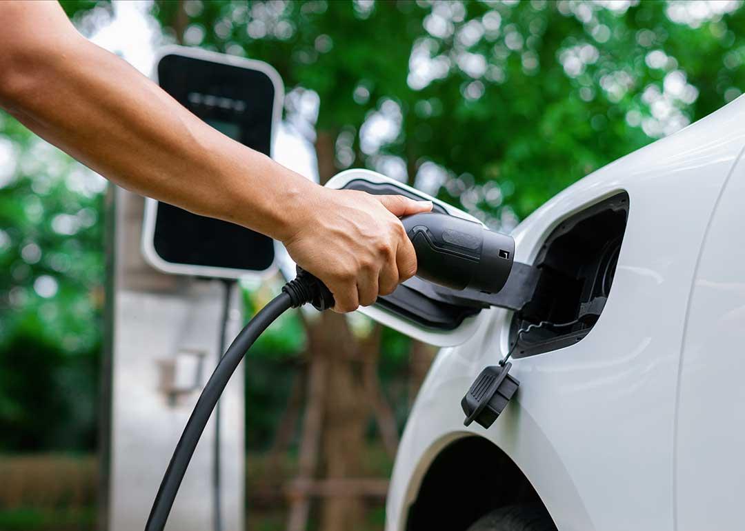 person plugging electric vehicle charger into car