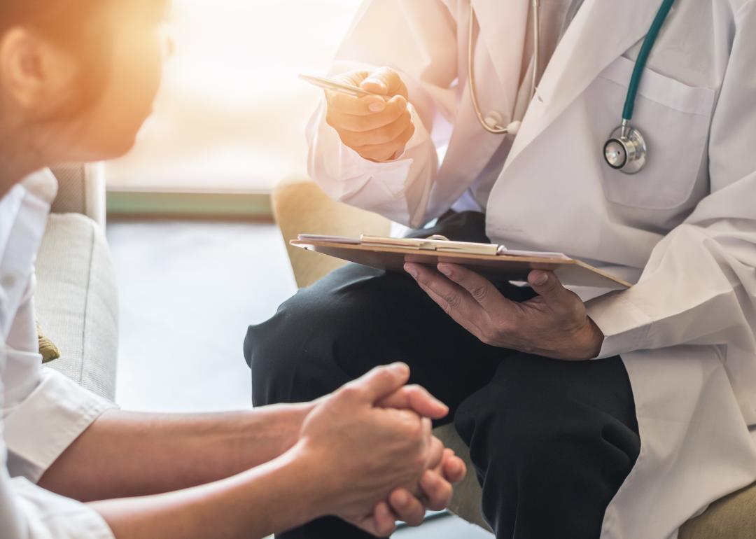 side profile of woman meeting with doctor holding clipboard