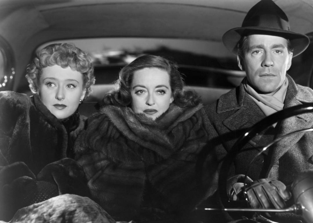 Actors Celeste Holm, Bette Davis, and Hugh Marlowe driving in the front seat of a car in the Best Picture winner 'All About Eve.'