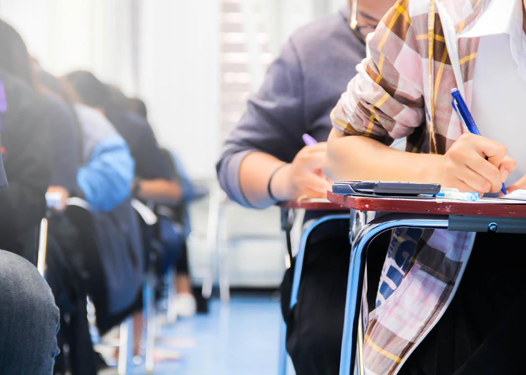 close up of students sitting at desks writing