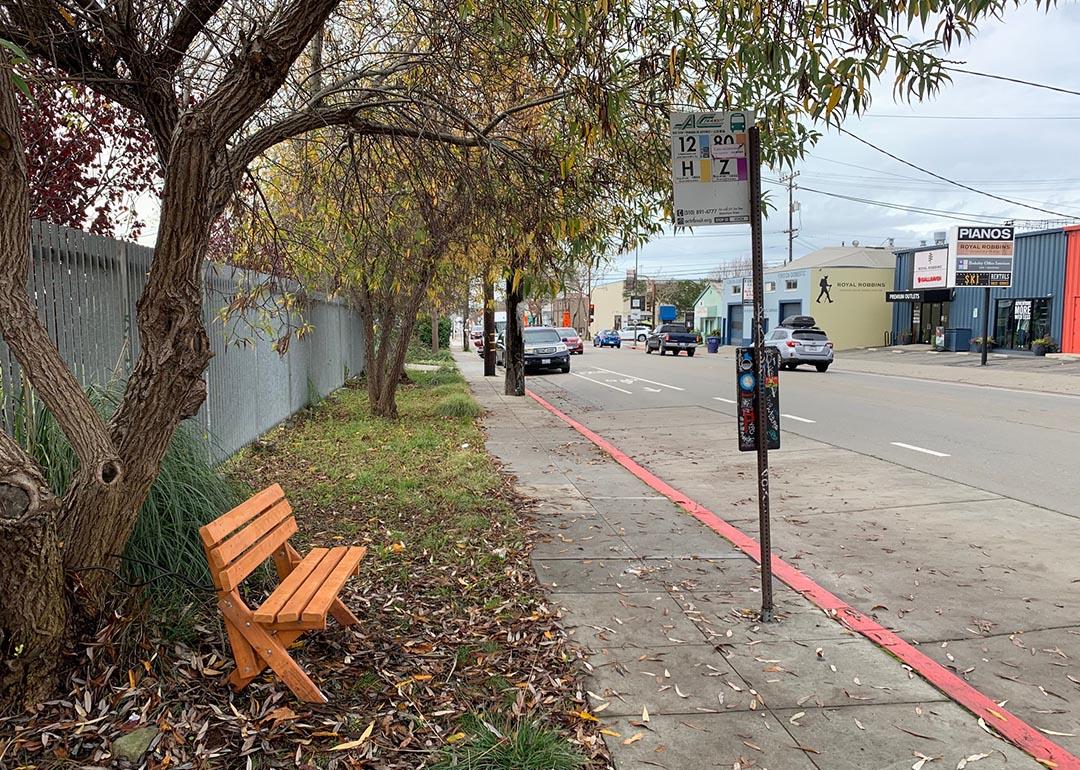 wooden bench next to bus stop
