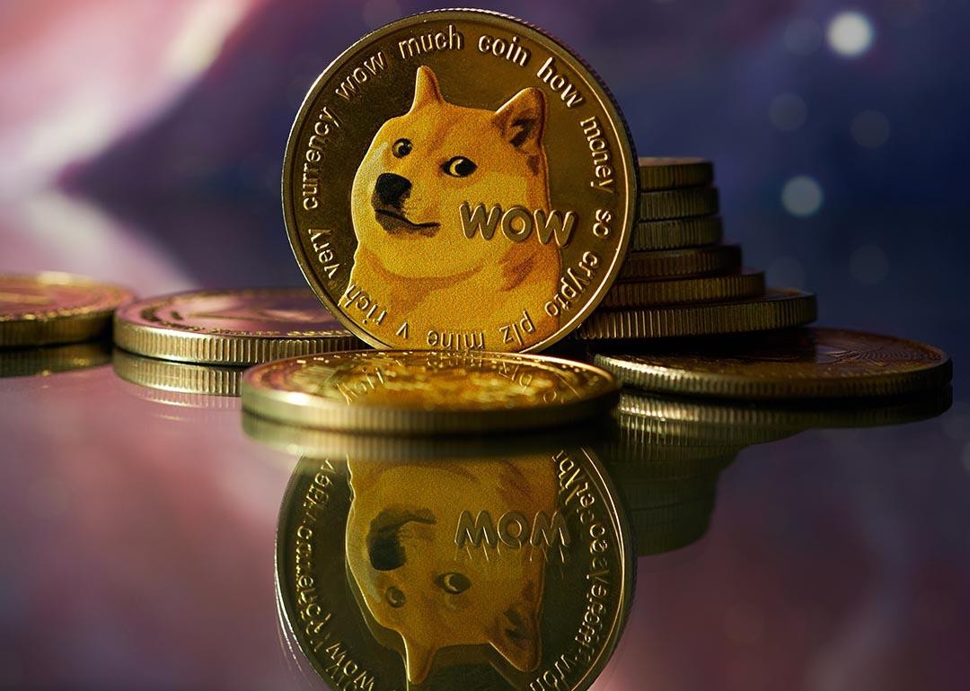 Dogecoin with Shiba Inu face balanced on reflective surface with abstract purple and pink background.