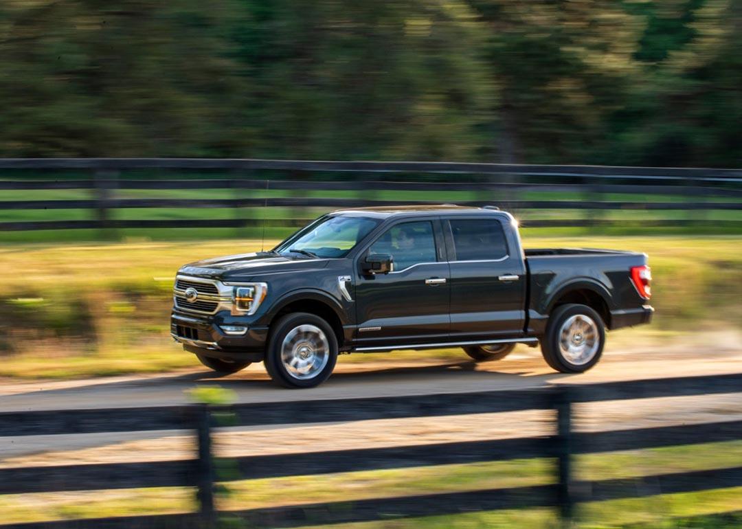A black 2022 Ford F-150 hybrid pickup truck driven on-road.