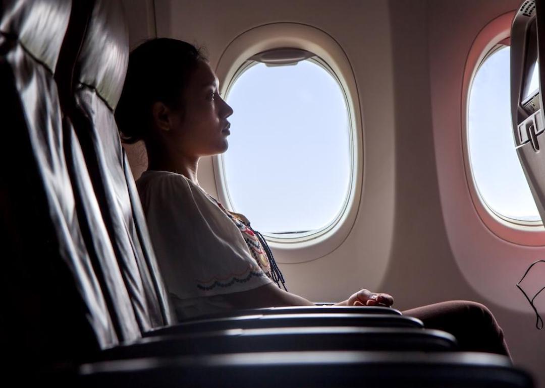 Passenger sitting on an airplane watching a monitor.