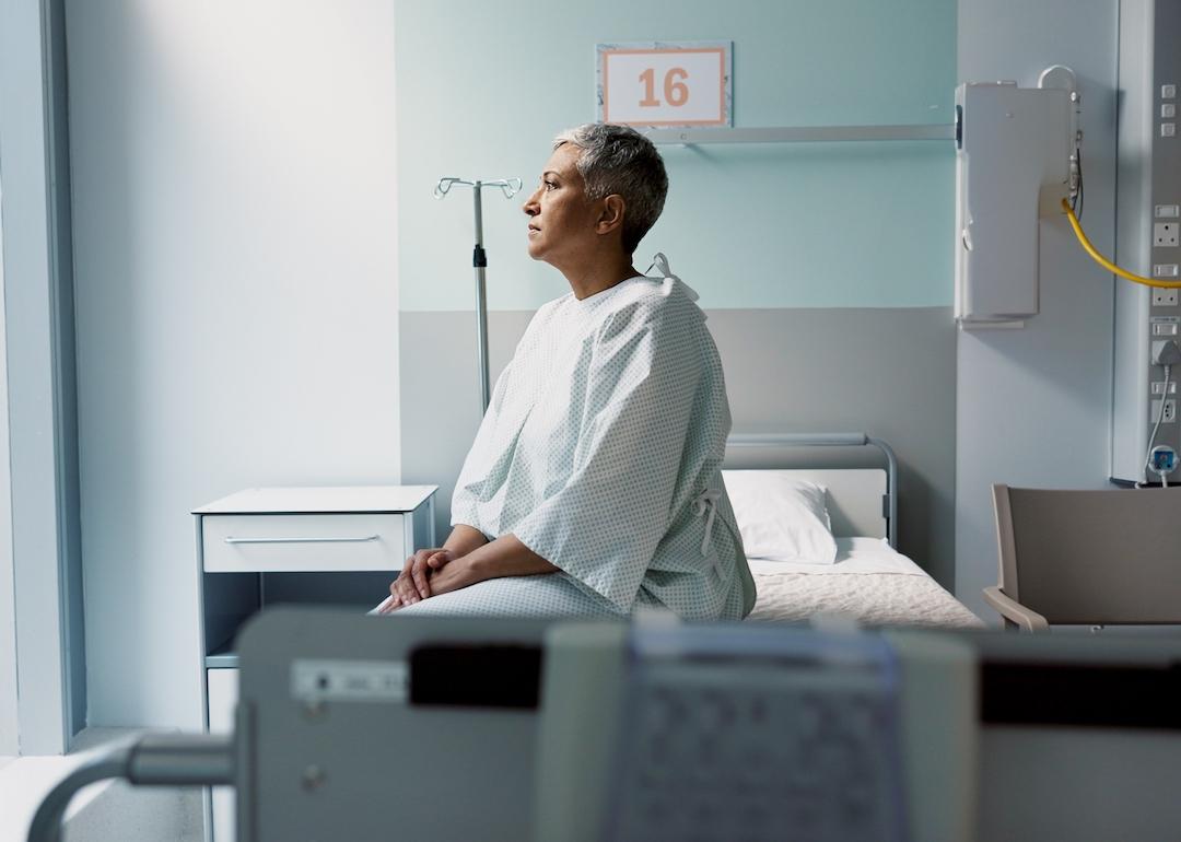 A patient with cancer sits on their hospital bed.