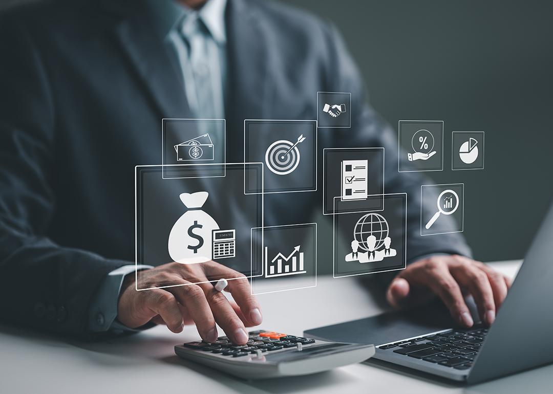 A business employee using a laptop illustrated with holographic concept icons of payroll and expense processes.