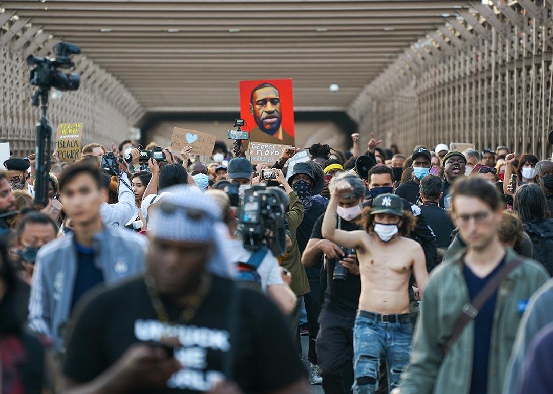 Marchers cross the Brooklyn Bridge demanding police reform after a commemoration to honor the anniversary of George Floyd's death on May 25, 2021 in New York City,