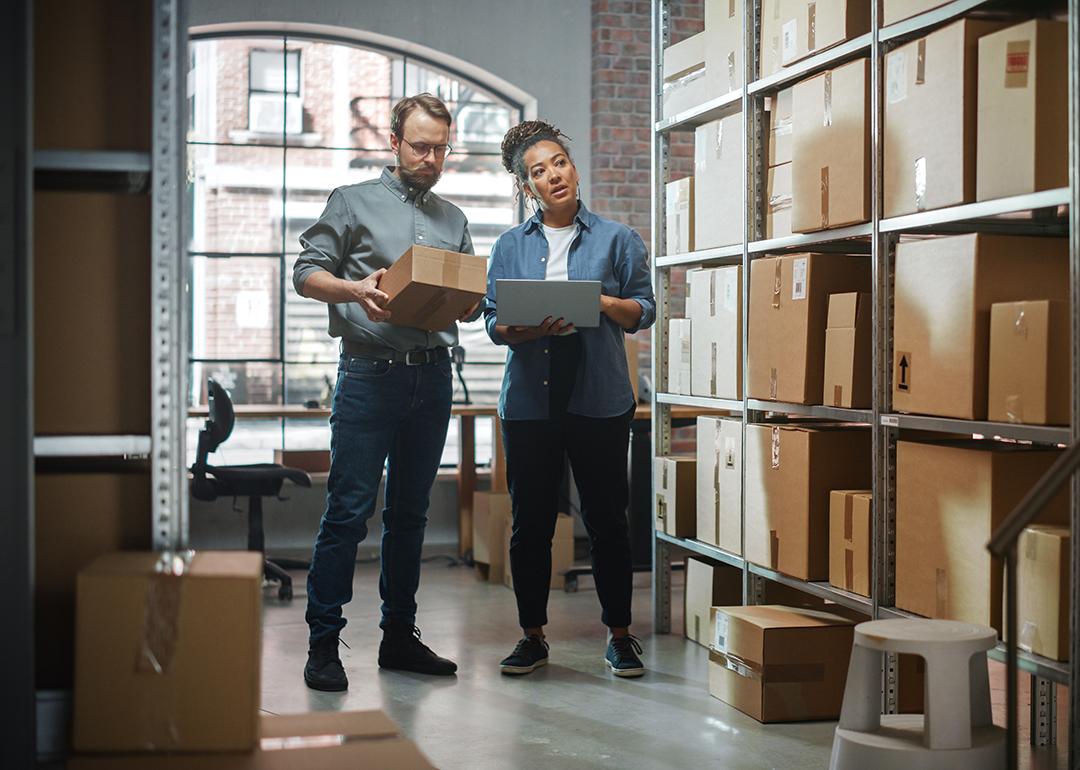 Two small business owners carefully inspecting products and inventory area.