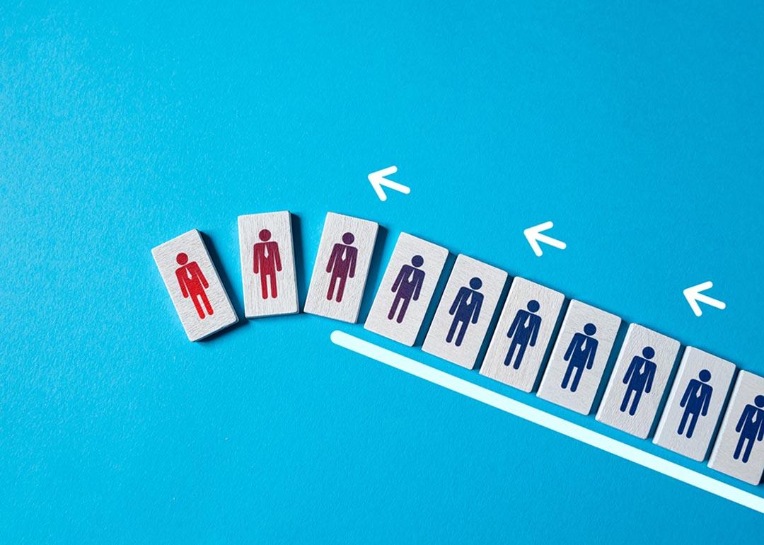 A row of tiles with employee figures falling over as a concept of employee turnover.