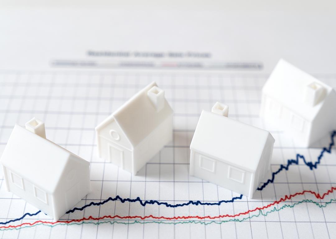 Four pieces of 3D models of houses over an investment chart.