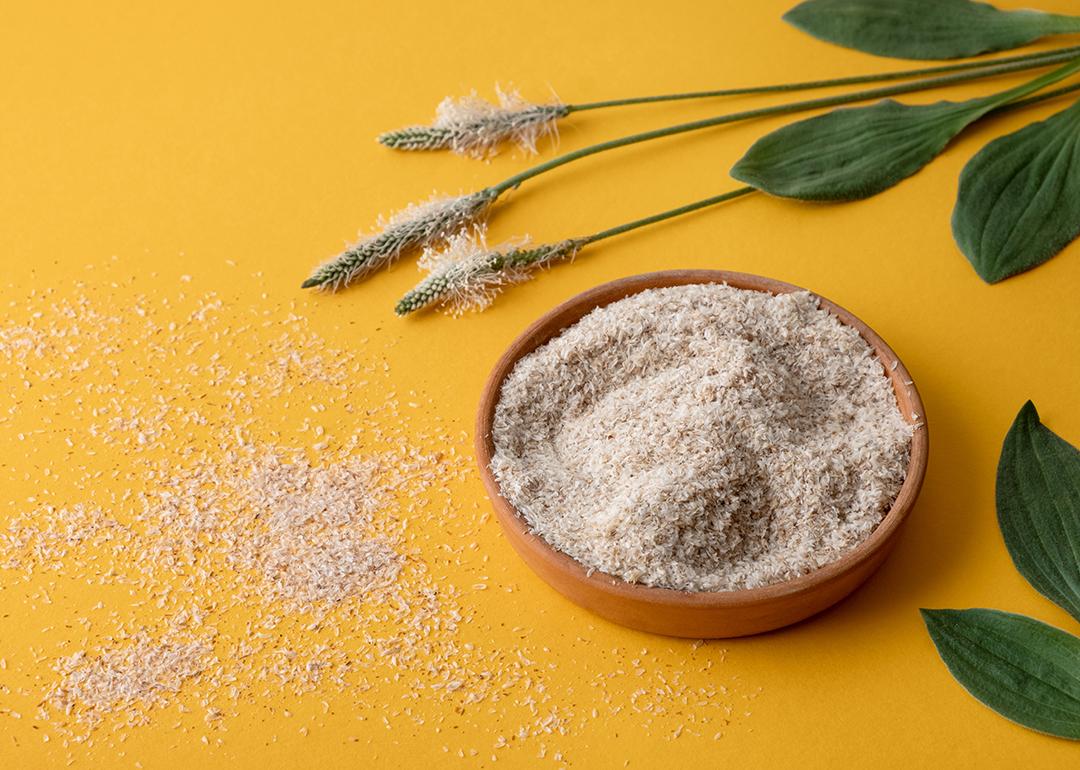 Psyllium plant product in a plate on yellow background.