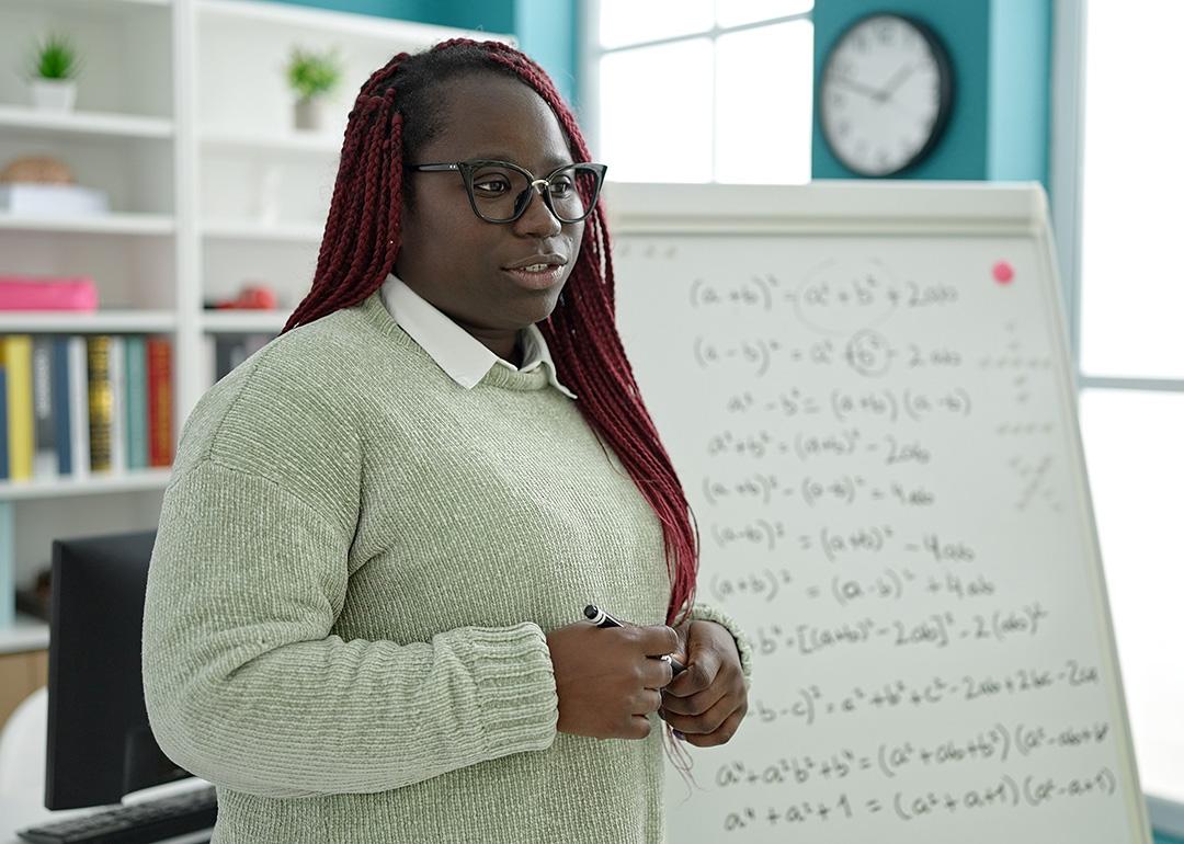 A black female teacher holding lessons in mathematics in a classroom.