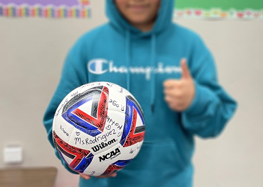 A fifth grader who left Areli Rodriguez's Texas classroom because his family feared being detained by immigration agents holds the signed soccer ball he received as a parting gift.