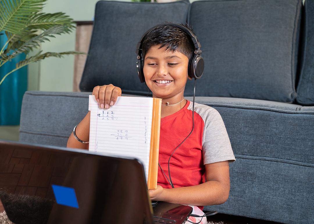 A kid virtually interacting with a tutor using a laptop.