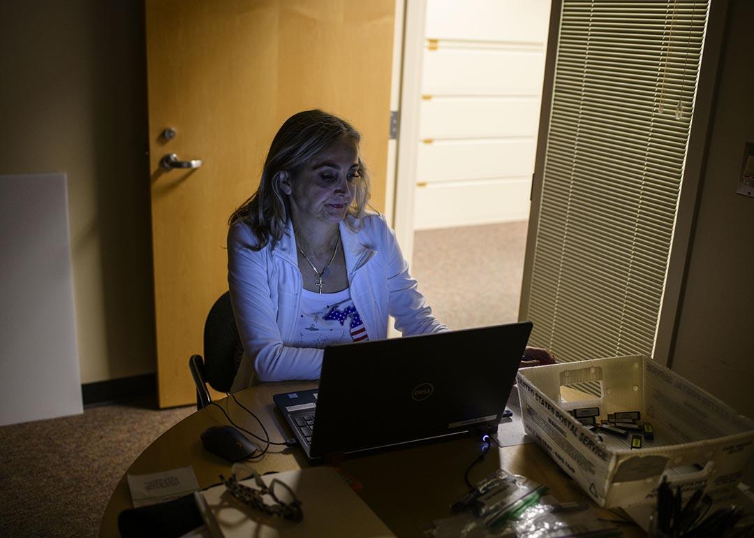 Election clerk working in a dark office on a computer.