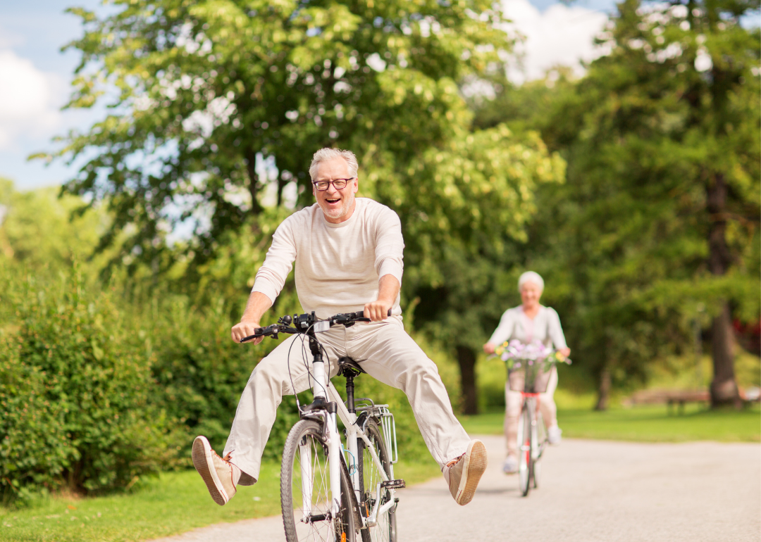 Happy senior couple riding bicycles in the park