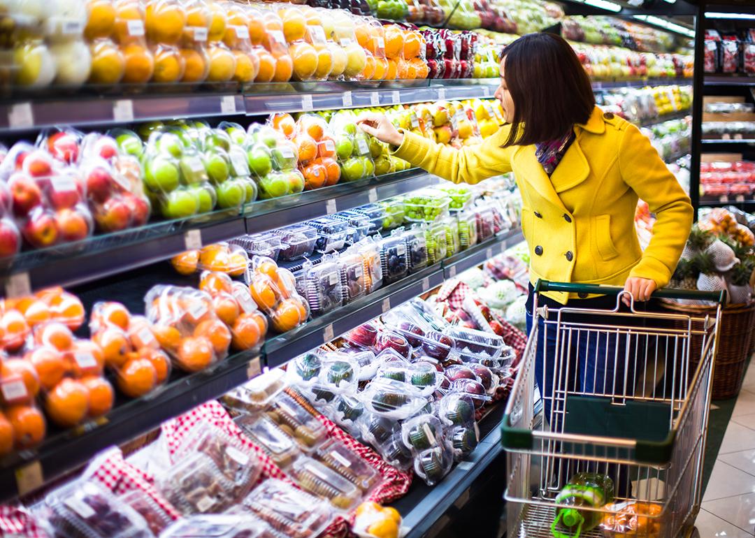 A woman shopping at the fruits section of a supermarket.