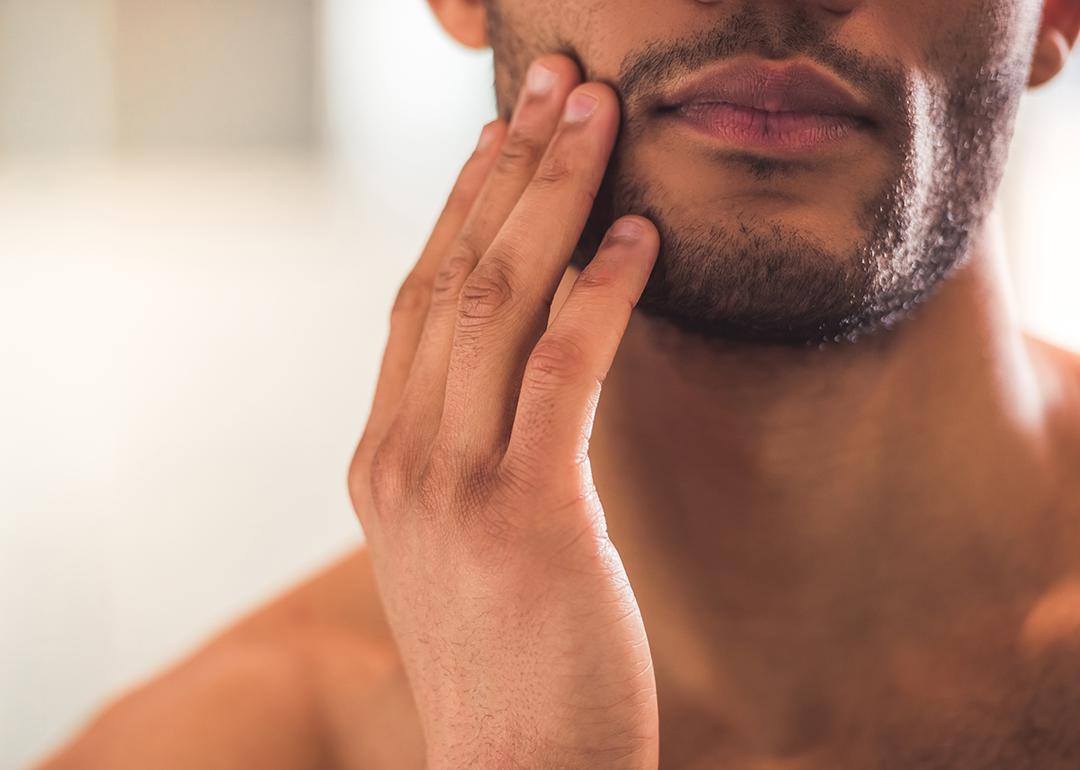 Closeup on a man touching his beard.