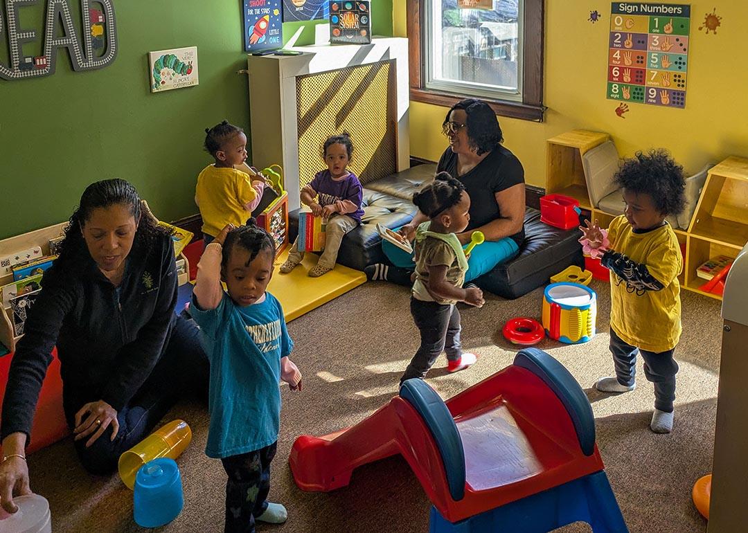 Toddlers play in a colorful room at Sandra Dill’s family child care in a colorful room.