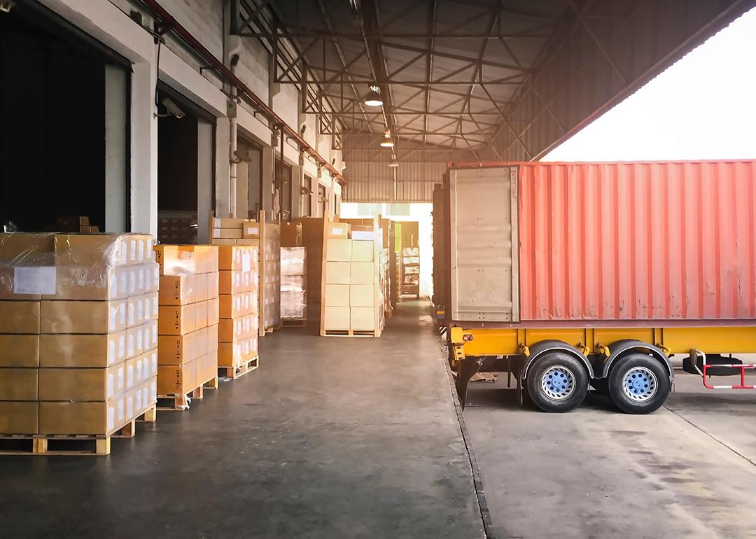 Cargo shipment and a trailer truck parked for loading at a dock warehouse.