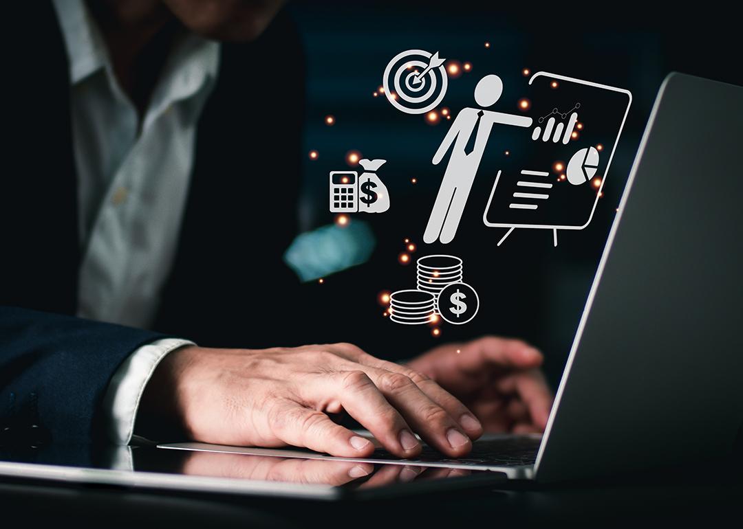 Businessperson using a laptop and finance and treasure holographic icons are illustrated as a concept of a management system software.