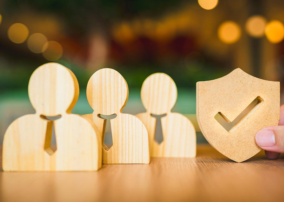 Wooden symbols for employees and a shield for insurance.