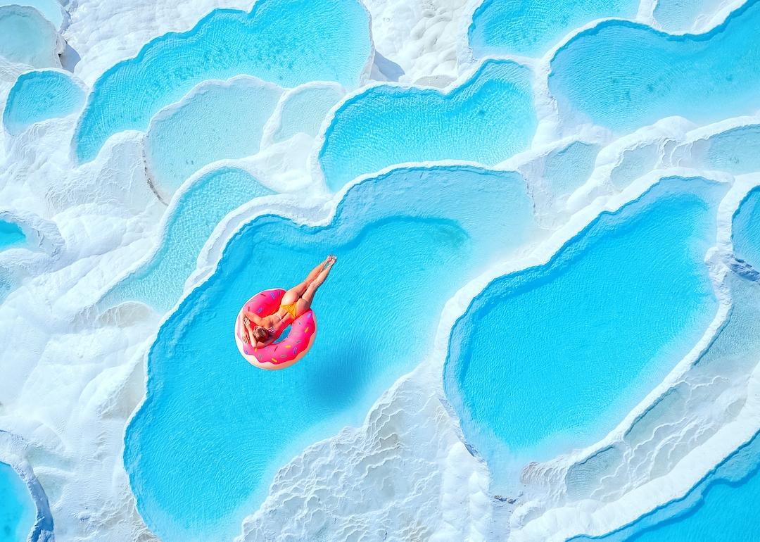 Person on pink inflatable donut in Travertine pools in Pamukkale, Turkey.