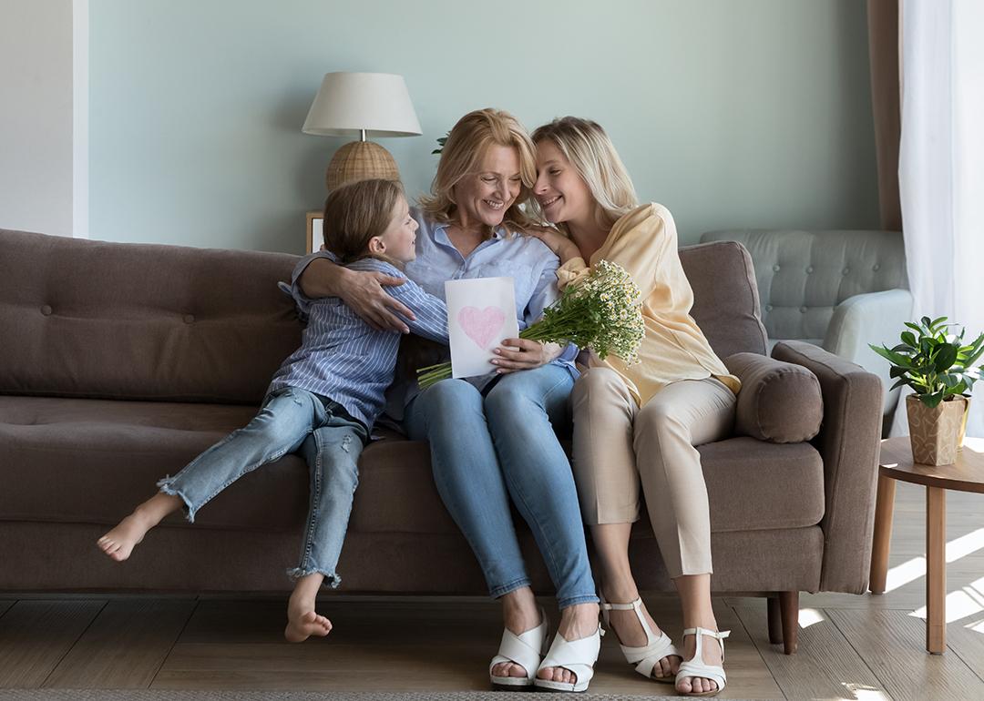 A mother receives Mother's Day gifts at home from her adult daughter and grandson .