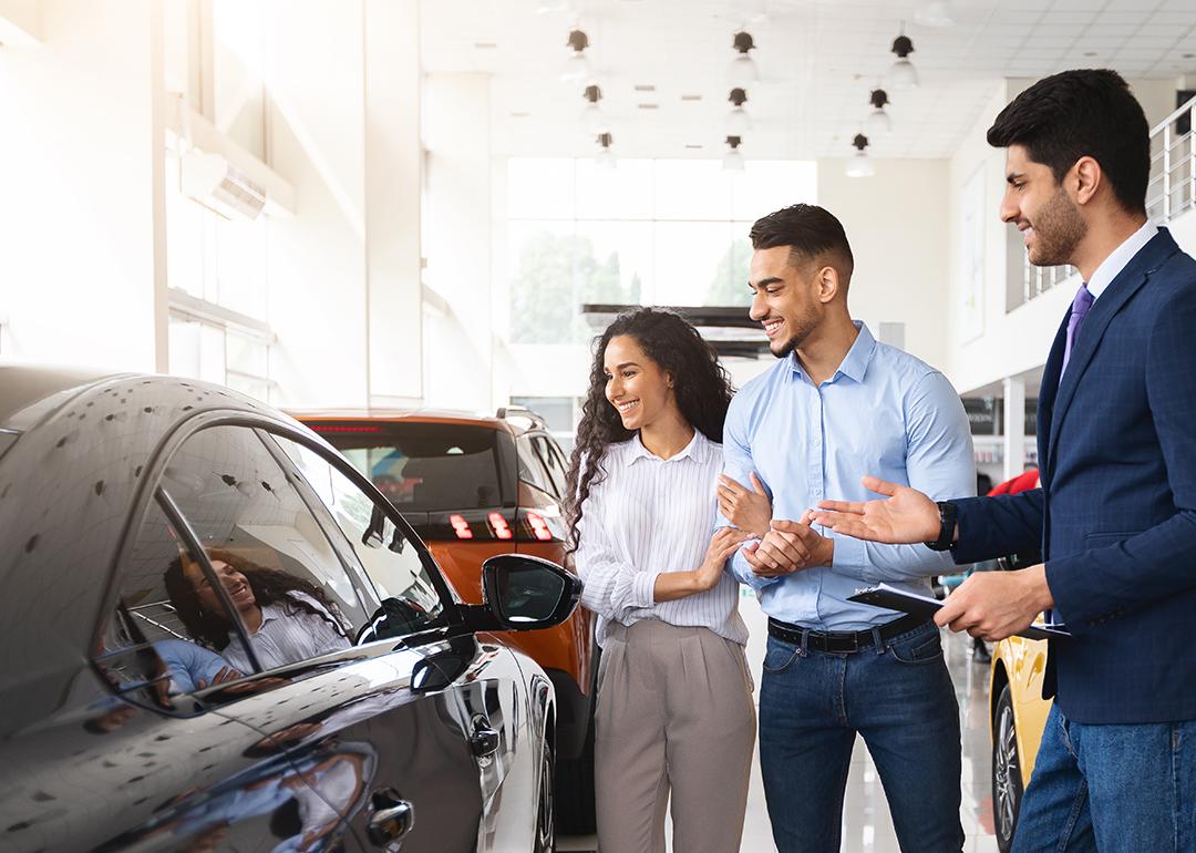 Couple looking into purchasing a car in a dealer.