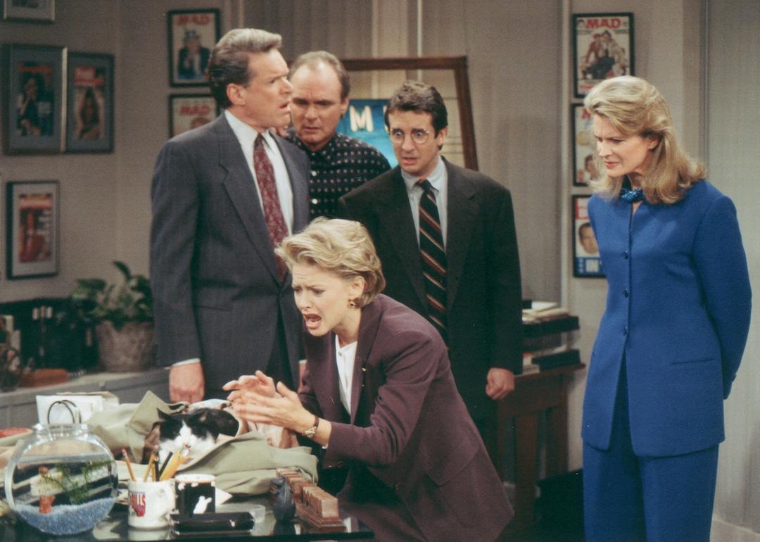 Charles Kimbrough, Joe Regalbuto, Grant Shaud, and Candice Bergen watch Faith Ford with a cat in a scene from “Murphy Brown,” 1990s.