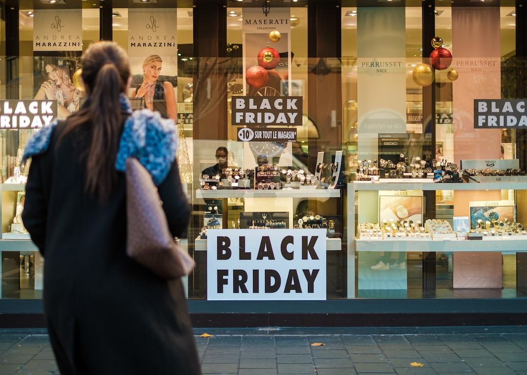 Person standing in front of a shop on Black Friday.