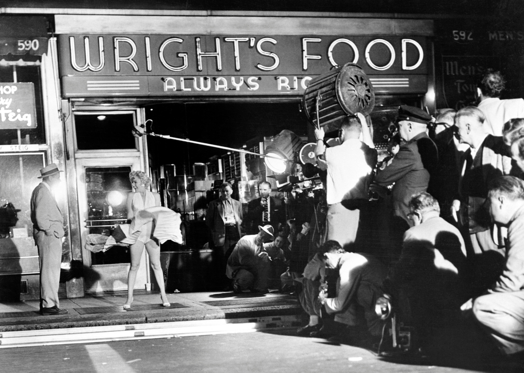 Marilyn Monroe standing over a subway grating with her skirts blown up by a giant blower while talking to Tom Ewell in a scene from the movie "Seven-Year Itch."