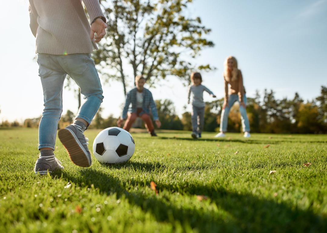 Kids playing soccer in park.