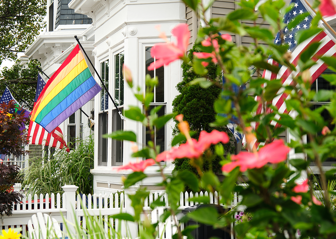 A rainbow pride flag and American flags affixed to a home.