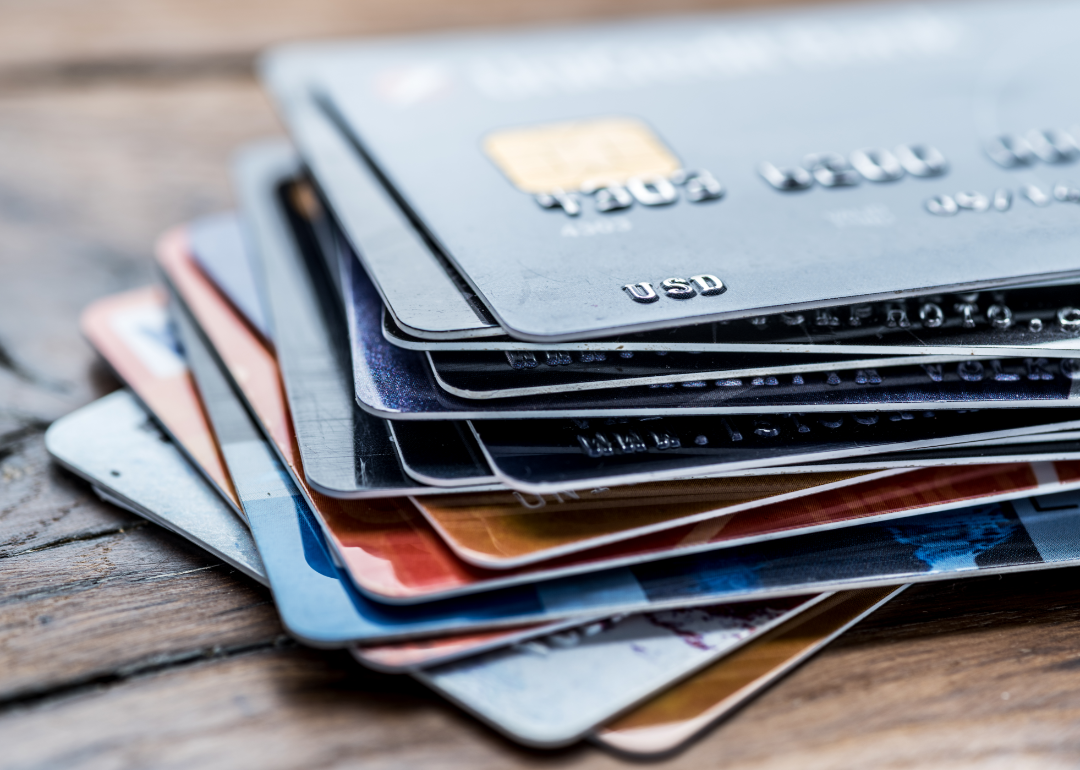 A stack of credit cards resting on a wooden table