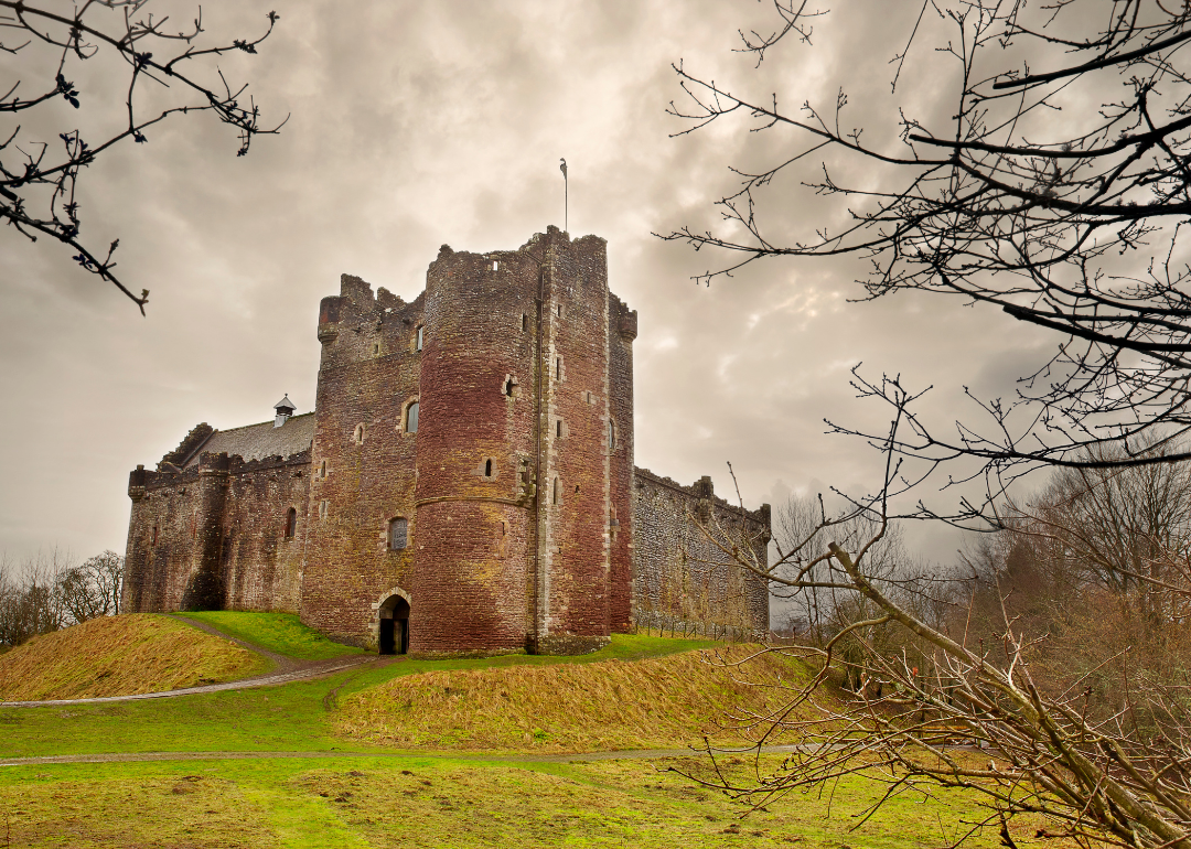 A castle made of gray stone with a number of towers, the tallest of which is in the center of the castle.
