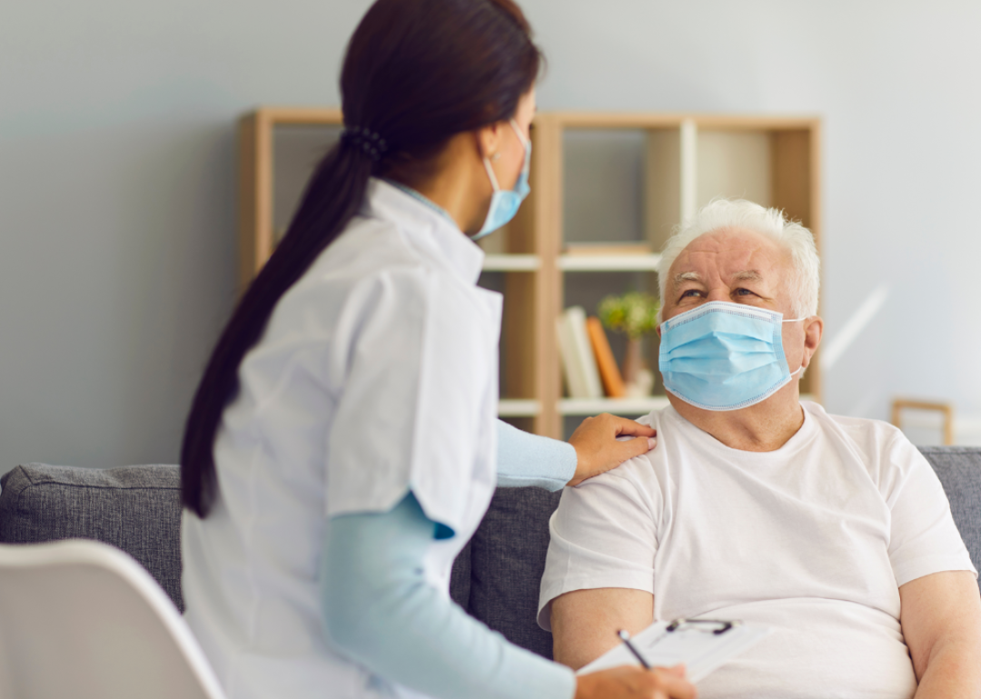A health worker visiting a senior male patient at home.