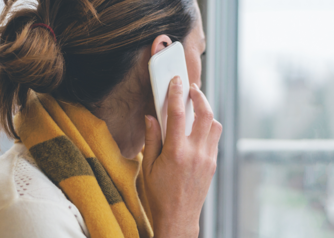 A woman on a phone call looking out a window.