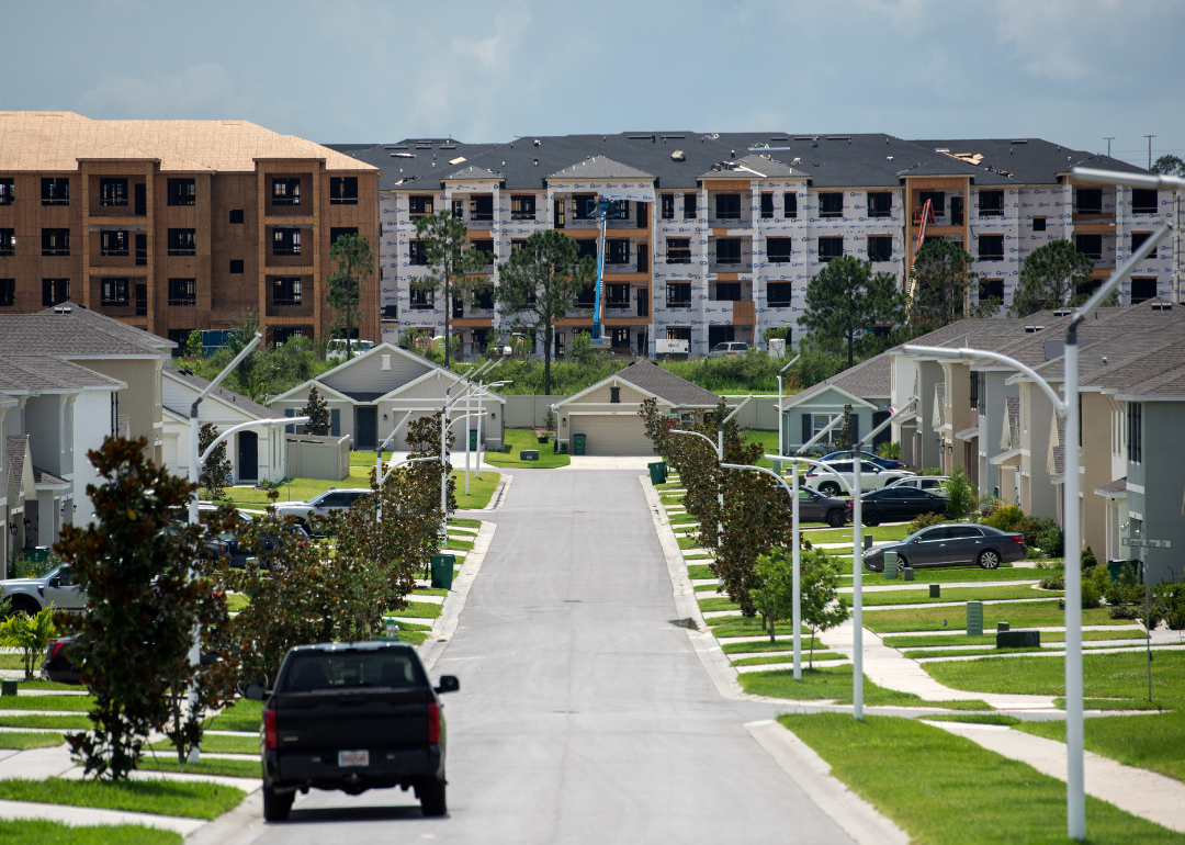 A neighborhood of nice homes with apartment buildings under construction in the background.