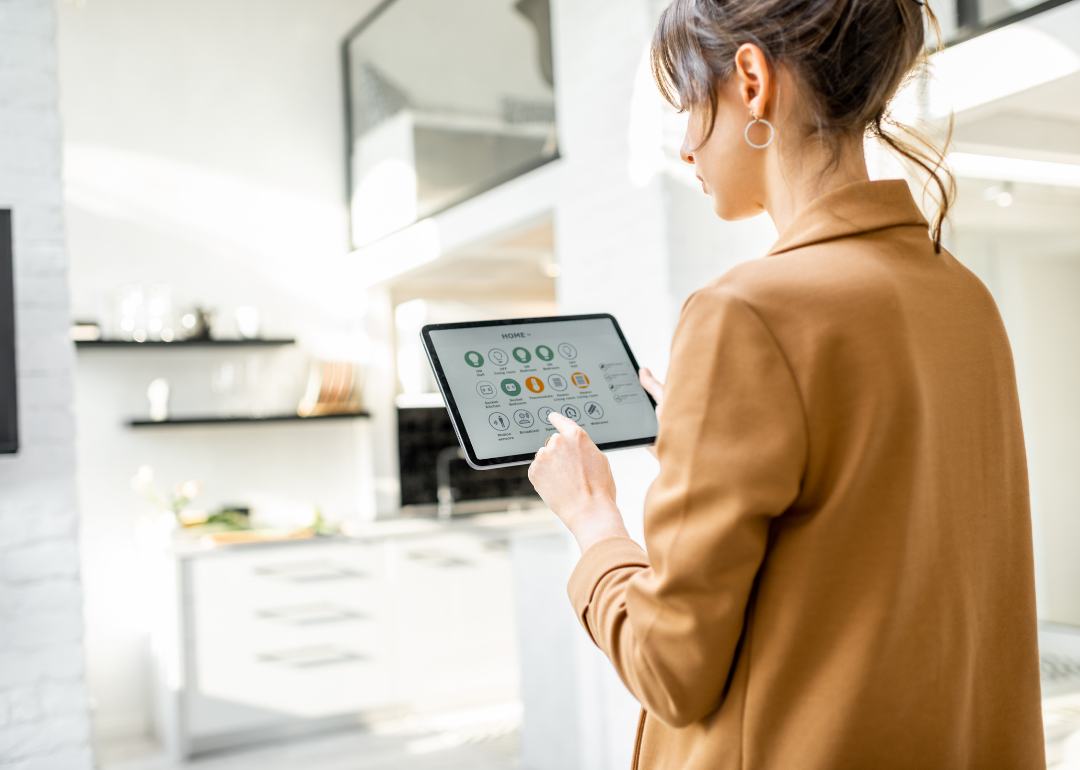 A woman controlling her smart home on a tablet