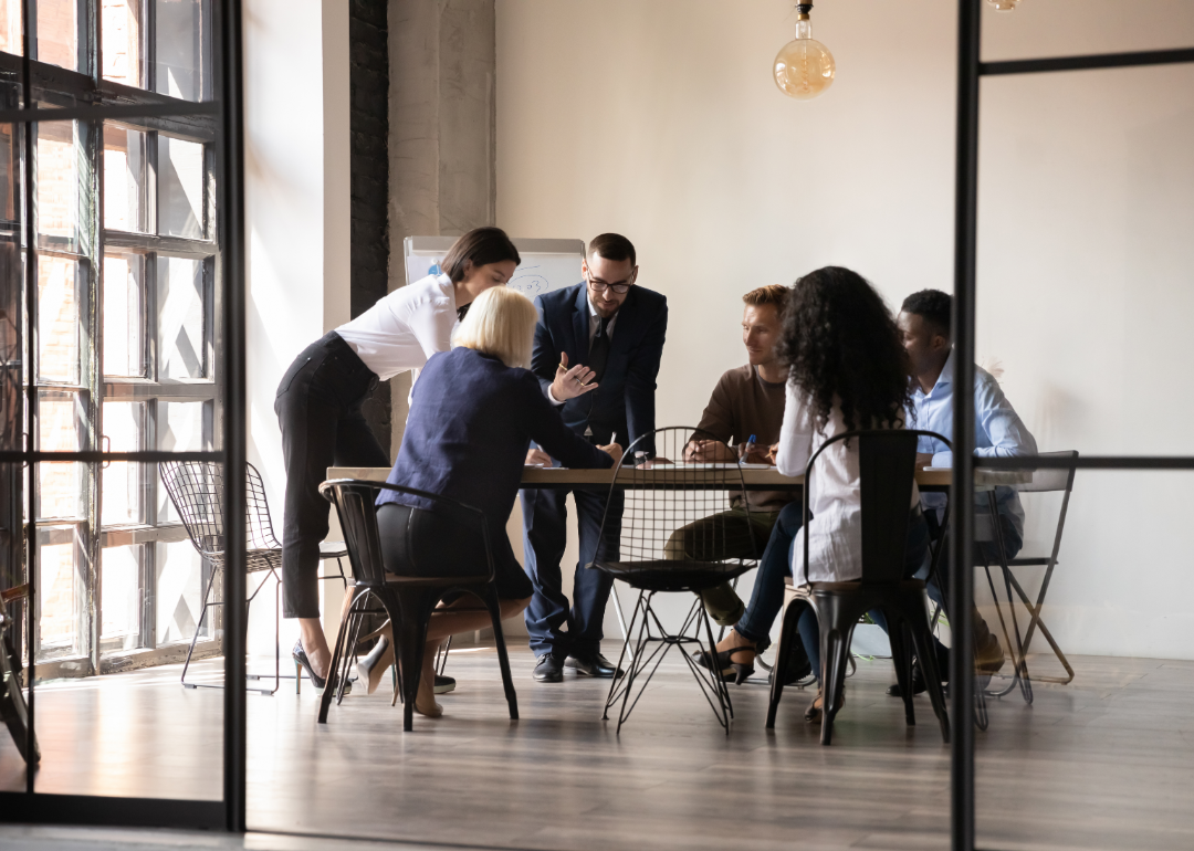 A team of employees meeting in a modern boardroom.