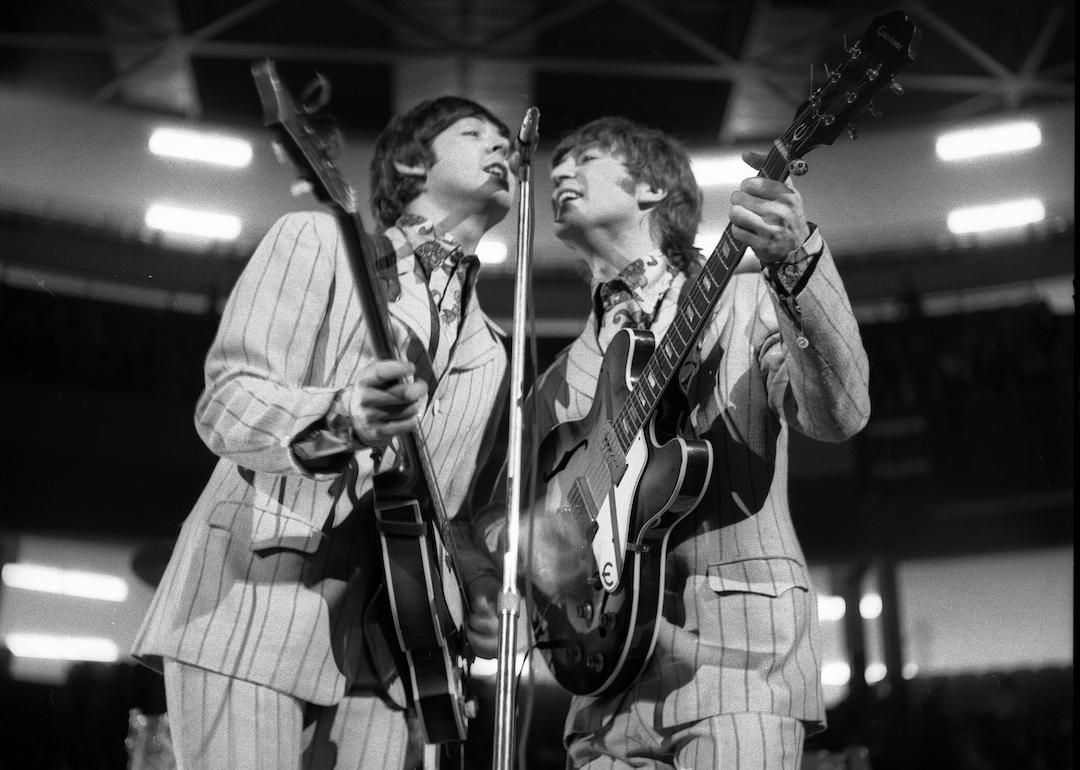 Beatles band members Paul McCartney (left), on bass, and John Lennon (right), on guitar, perform onstage at Olympia Stadium in Detroit, Michigan, in 1966.