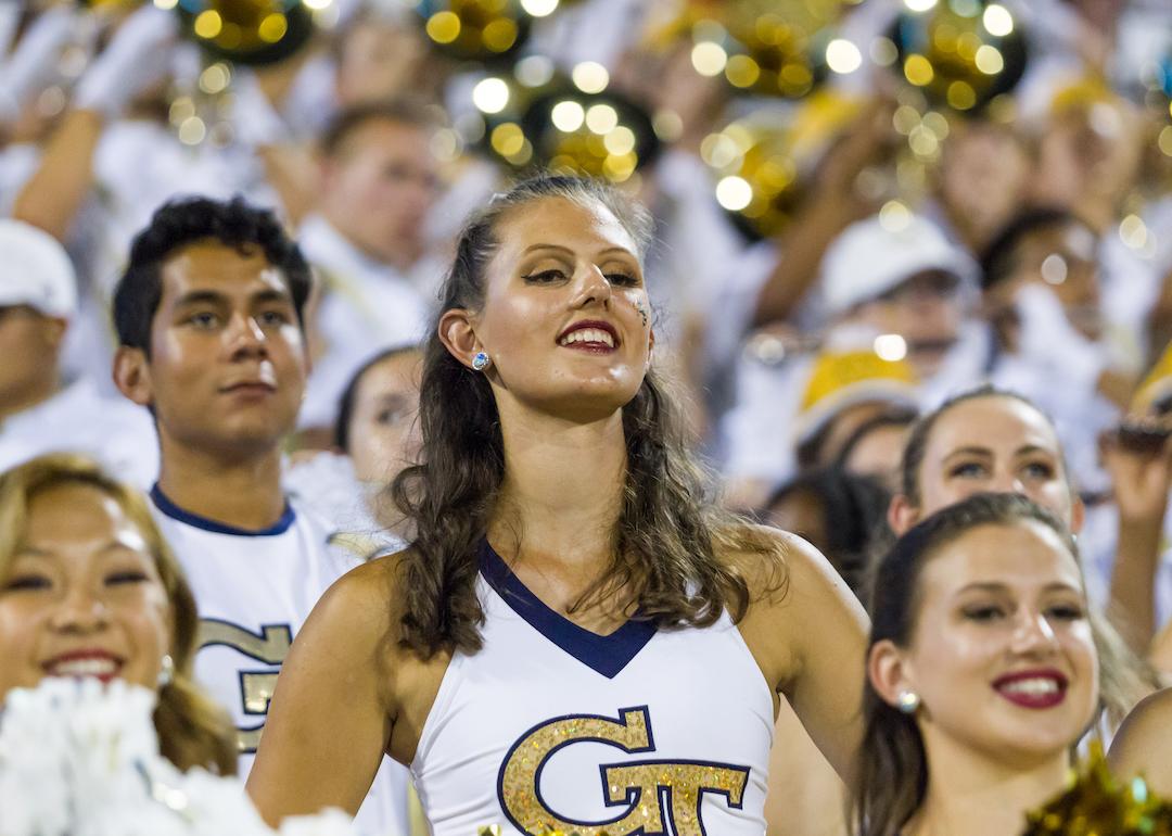 Georgia Tech Yellow Jackets cheerleaders stand in crowd.