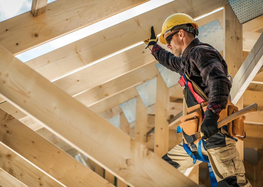 Construction worker on duty standing on wooden frame.